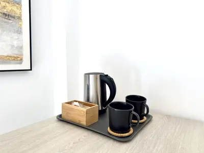 a tray with two coffee cups and a box at Hotel Apartamentos Marina Luz in Chipiona