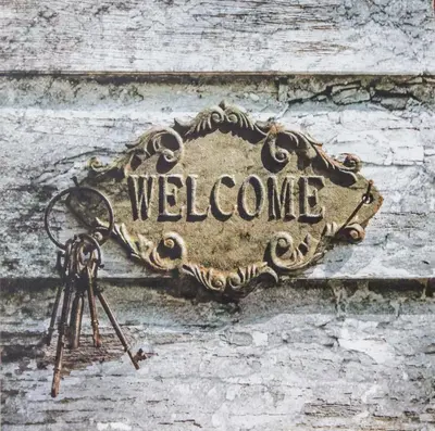 a welcome sign on a wall with a pair of keys at Apartamentos Las Huertas in Cádiz