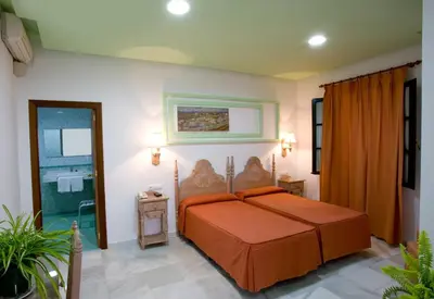 a bedroom with a bed with an orange bedspread at Los Helechos in Sanlúcar de Barrameda