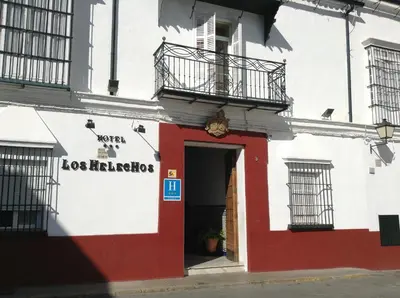 a red and white building with a door and balcony at Los Helechos in Sanlúcar de Barrameda