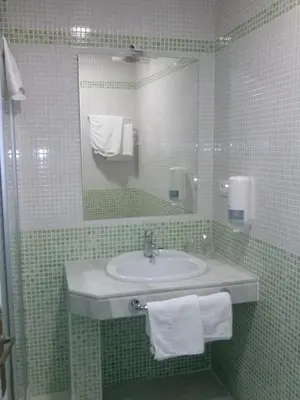 a bathroom with a sink and a mirror and towels at Los Helechos in Sanlúcar de Barrameda