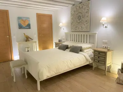 a bedroom with a white bed and a wooden floor at No 14 Cádiz in Cádiz