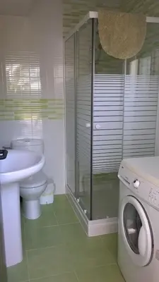 a bathroom with a toilet sink and a washing machine at Chalet en Hozanejos RS in Chiclana de la Frontera