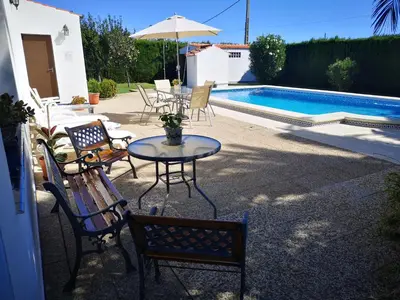a patio with a table and chairs next to a pool at Chalet en Hozanejos RS in Chiclana de la Frontera