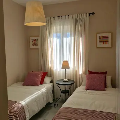 a bedroom with two beds and a table with a lamp at Apartamento Costa Ballena in Rota