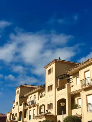 a large apartment building with a blue sky in the background at Apartamento Costa Ballena in Rota