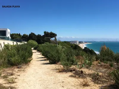 a dirt road leading down to the beach at Apartamentos Bahía Blanca in El Puerto de Santa María