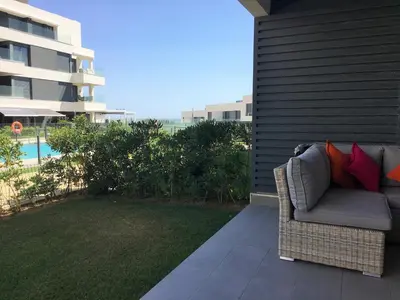 a couch with red pillows sitting on a patio at Apartamentos Bahía Blanca in El Puerto de Santa María