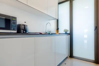 a kitchen with white cabinets and a microwave at Apartamentos Bahía Blanca in El Puerto de Santa María