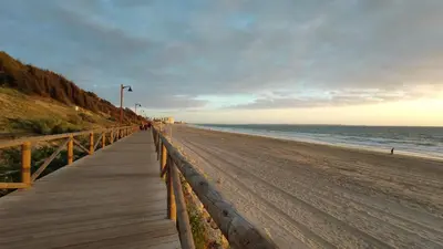 a wooden boardwalk leading down to the beach at Apartamentos Bahía Blanca in El Puerto de Santa María