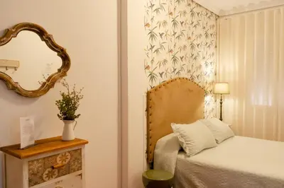 a bedroom with a bed and a mirror and a chair at Rompeolas Playa in Chipiona