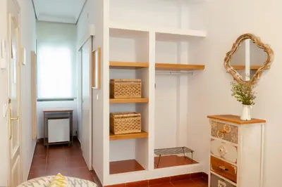 a room with a hallway with shelves and a table at Rompeolas Playa in Chipiona