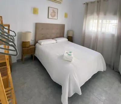 a bedroom with a large white bed with white sheets at Hostal Avenida by Bossh! Hotels in Chipiona