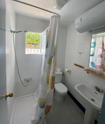 a bathroom with a shower and a toilet and a sink at Hostal Avenida by Bossh! Hotels in Chipiona
