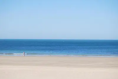 a person standing on a beach near the ocean at Hostal Avenida by Bossh! Hotels in Chipiona