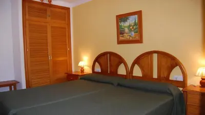 a bedroom with a bed with two lamps on two tables at Hotel Antonio Conil in Conil de la Frontera