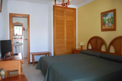 a bedroom with a green bed and a television at Hotel Antonio Conil in Conil de la Frontera