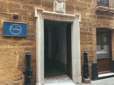 a door to a building with a sign on it at Apodaca Rooms in Cádiz