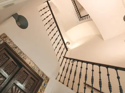 a staircase in a house with a wooden door at Apodaca Rooms in Cádiz