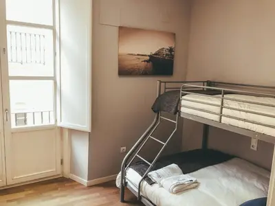 a bunk bed in a room with a window at Apodaca Rooms in Cádiz
