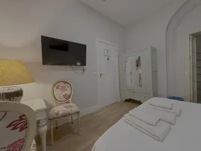 a bedroom with a bed and a tv on the wall at Apodaca Rooms in Cádiz