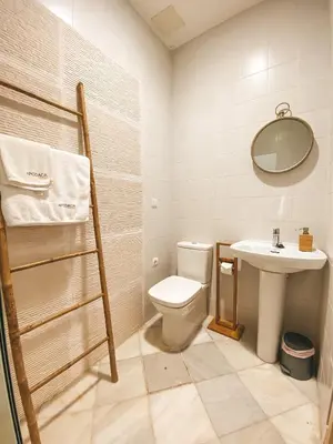 a bathroom with a toilet and a sink at Apodaca Rooms in Cádiz