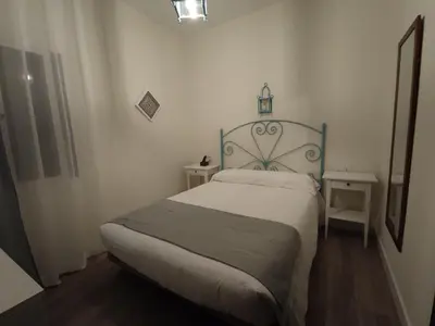 a bedroom with two beds and a mirror at Hostal Andalucía in Chipiona