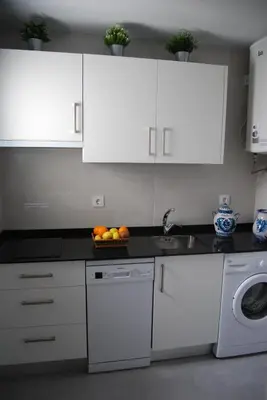 a kitchen with white cabinets and a bowl of fruit on the counter at La casa De Los Faros in El Puerto de Santa María