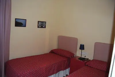 a room with two beds and a table and two chairs at La casa De Los Faros in El Puerto de Santa María