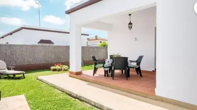 a patio with a table and chairs in a yard at Casa Colada 3 in Conil de la Frontera