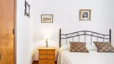 a bedroom with a bed and a table with a lamp at Casa Colada 3 in Conil de la Frontera