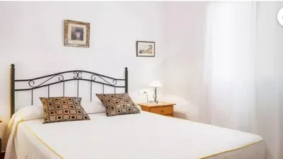 a bedroom with a white bed with two pillows at Casa Colada 3 in Conil de la Frontera