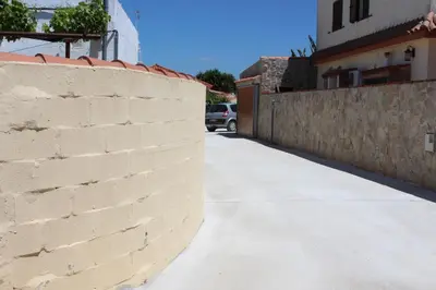a brick wall next to a sidewalk next to a building at Casa Colada 3 in Conil de la Frontera