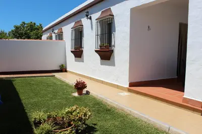 a white house with two windows and a yard at Casa Colada 3 in Conil de la Frontera
