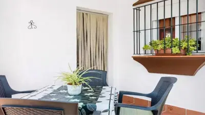 a table and chairs with plants on a balcony at Casa Colada 3 in Conil de la Frontera