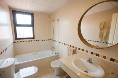 a bathroom with a sink and a toilet and a mirror at Casa Manzanilla in Sanlúcar de Barrameda