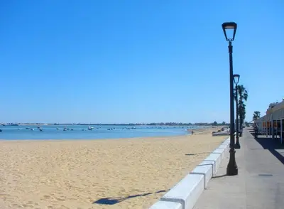 a beach with a light pole and the water at Casa Manzanilla in Sanlúcar de Barrameda