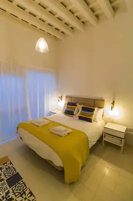 a bedroom with a large bed with a yellow blanket at SH Rosario. Loft chic en el centro histórico in Cádiz