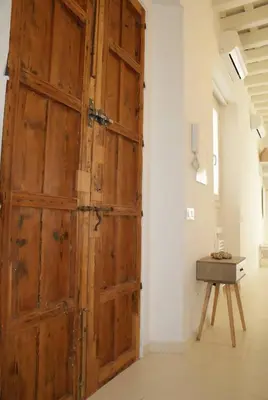 a large wooden door in a room with a table at SH Rosario. Loft chic en el centro histórico in Cádiz