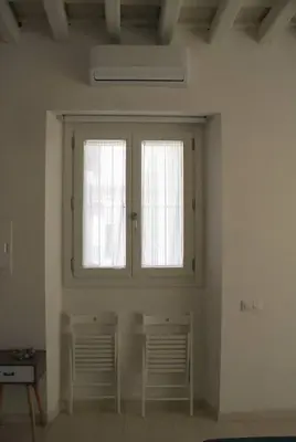 two windows in a white room with two chairs at SH Rosario. Loft chic en el centro histórico in Cádiz
