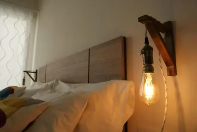 a bedroom with a bed with a light on the wall at SH Rosario. Loft chic en el centro histórico in Cádiz