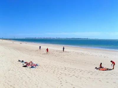 a group of people on a beach near the ocean at Chalet a 100m de la playa en El Puerto in El Puerto de Santa María