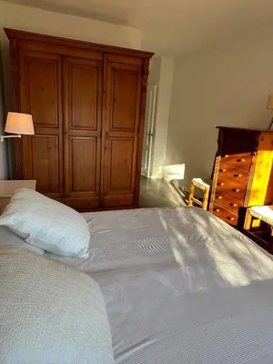 a bedroom with a large bed with a wooden cabinet at Chalet a 100m de la playa en El Puerto in El Puerto de Santa María