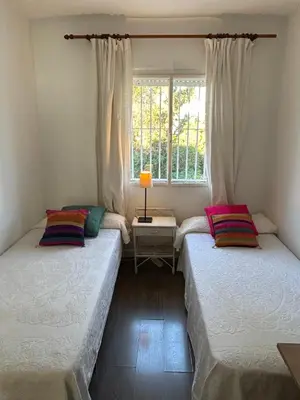 two beds in a room with a window at Chalet a 100m de la playa en El Puerto in El Puerto de Santa María