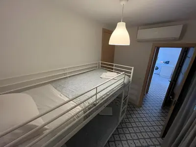 a bunk bed in a small room with a light at El Rincón de la Playa SantaMaría Grupo AC Gestion in Cádiz