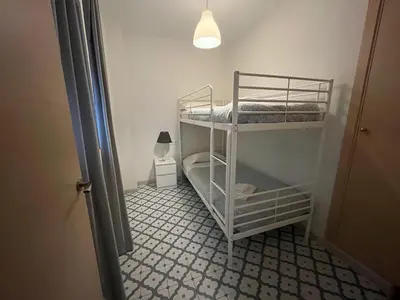 a room with two bunk beds and a lamp at El Rincón de la Playa SantaMaría Grupo AC Gestion in Cádiz