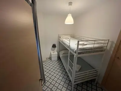a room with two bunk beds and a lamp at El Rincón de la Playa SantaMaría Grupo AC Gestion in Cádiz