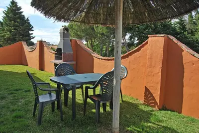 a picnic table and chairs under an umbrella at Hacienda Puerto Conil in Conil de la Frontera
