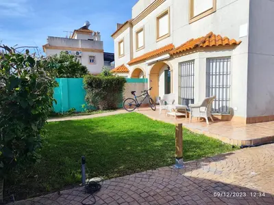 a house with a patio with a bike in the yard at La Pavona 11 - 1ª línea de Playa Chipiona in Chipiona