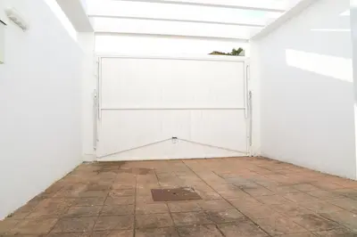 a room with a white garage door and a tile floor at Apto en Residencial El Bosque in Chiclana de la Frontera